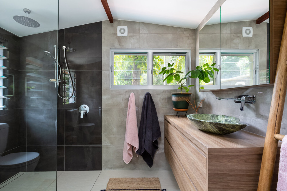 Trendy gray tile beige floor, single-sink and vaulted ceiling bathroom photo in Sunshine Coast with flat-panel cabinets, medium tone wood cabinets, a vessel sink, wood countertops, brown countertops and a floating vanity