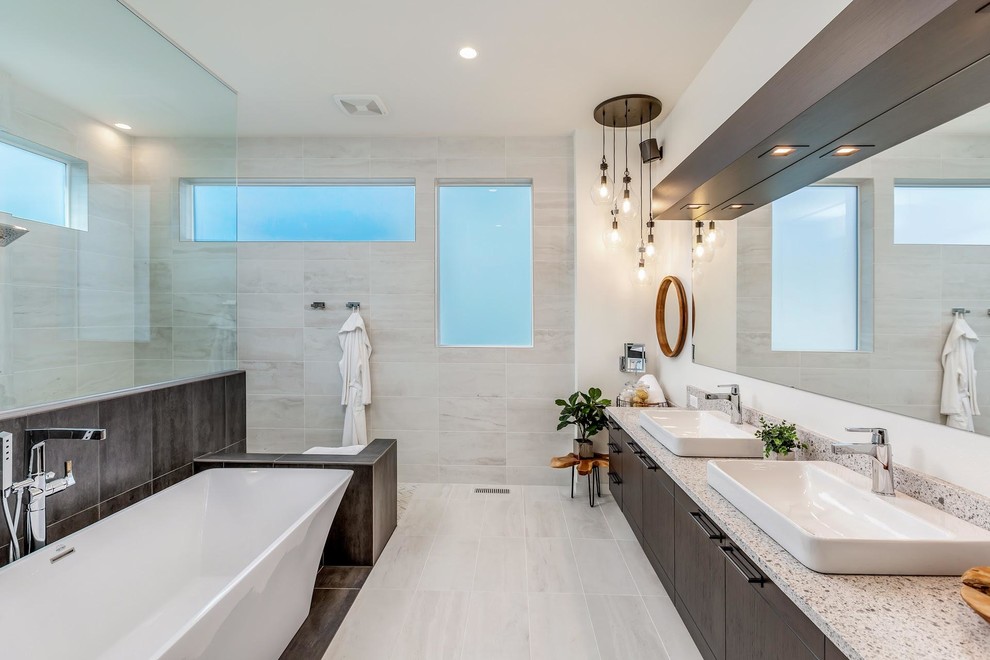 Inspiration för mellanstora moderna vitt en-suite badrum, med släta luckor, ett fristående badkar, vit kakel, porslinskakel, klinkergolv i porslin, ett fristående handfat, bänkskiva i kvarts, med dusch som är öppen, en kantlös dusch, skåp i mörkt trä, vita väggar och grått golv