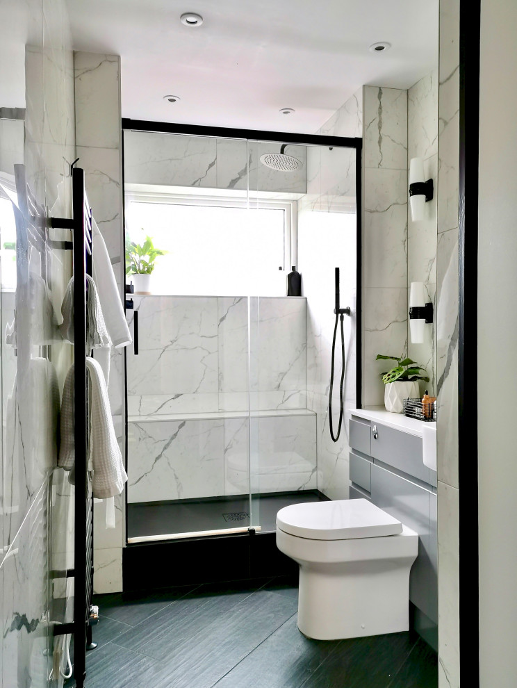Idée de décoration pour une petite salle d'eau design avec un placard à porte plane, des portes de placard grises, une douche à l'italienne, WC à poser, un carrelage blanc, des carreaux de céramique, un mur blanc, un sol en carrelage de porcelaine, un lavabo intégré, un sol noir, une cabine de douche à porte coulissante, un plan de toilette blanc, meuble simple vasque et meuble-lavabo encastré.