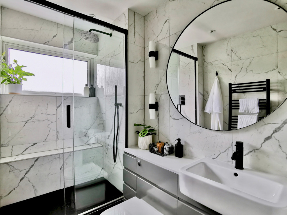 Источник вдохновения для домашнего уюта: маленькая ванная комната в современном стиле с плоскими фасадами, серыми фасадами, душем без бортиков, унитазом-моноблоком, белой плиткой, керамической плиткой, белыми стенами, полом из керамогранита, душевой кабиной, монолитной раковиной, черным полом, душем с раздвижными дверями, белой столешницей, тумбой под одну раковину и встроенной тумбой для на участке и в саду