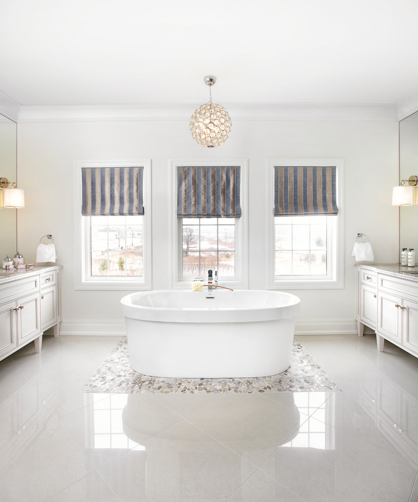 Foto di una stanza da bagno chic con ante con riquadro incassato, ante bianche, vasca freestanding e pareti bianche