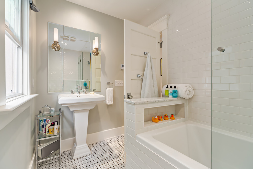 На фото: главная ванная комната среднего размера в классическом стиле с накладной ванной, душем над ванной, белой плиткой, керамической плиткой, серыми стенами, полом из керамической плитки, раковиной с пьедесталом и мраморной столешницей с