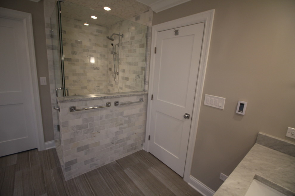 Klassisk inredning av ett mycket stort en-suite badrum, med skåp i shakerstil, vita skåp, ett fristående badkar, en öppen dusch, grå kakel, grå väggar, klinkergolv i porslin, ett undermonterad handfat och marmorbänkskiva