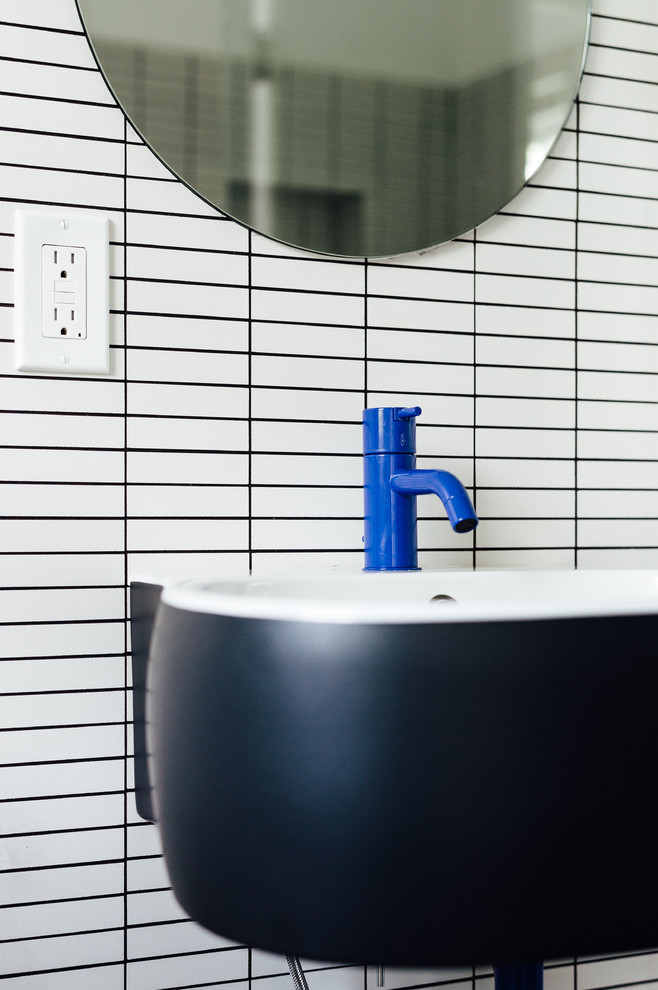 Foto på ett litet skandinaviskt en-suite badrum, med en dusch i en alkov, en toalettstol med hel cisternkåpa, vit kakel, porslinskakel, vita väggar, ett väggmonterat handfat och med dusch som är öppen
