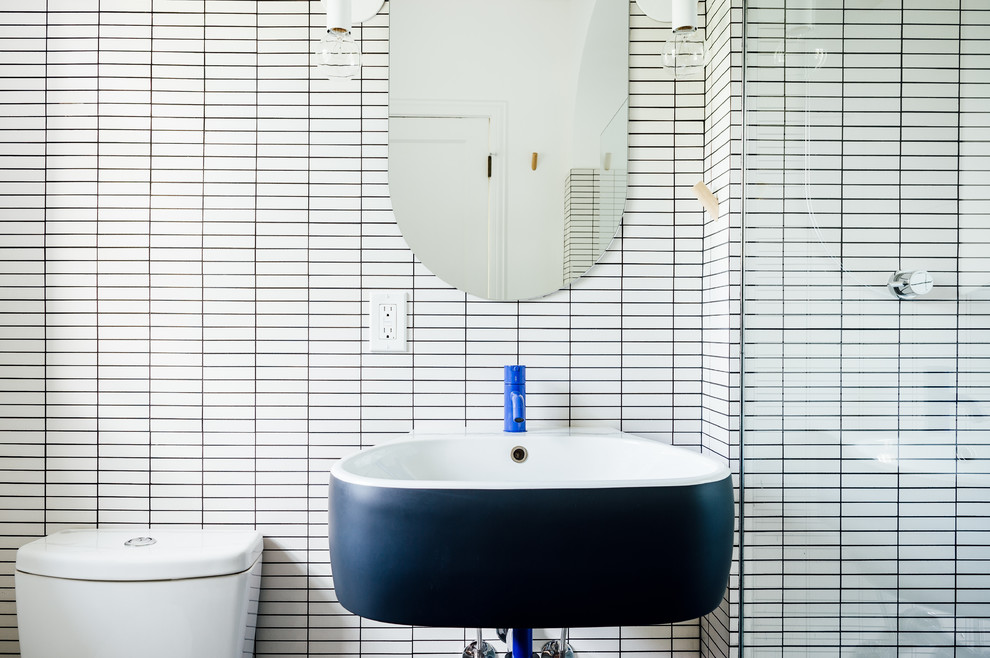 Cette image montre une petite douche en alcôve principale nordique avec WC à poser, un carrelage blanc, des carreaux de porcelaine, un mur blanc, un lavabo suspendu et aucune cabine.