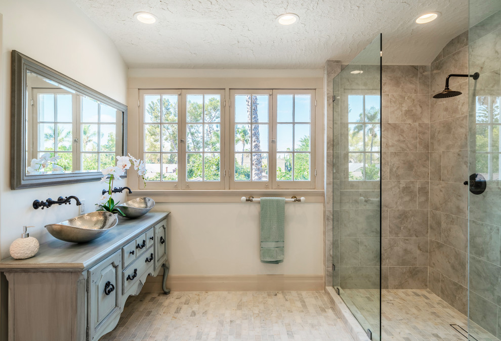 Inspiration for a medium sized traditional ensuite bathroom in Orange County with freestanding cabinets, blue cabinets, a double shower, grey tiles, ceramic tiles, white walls, marble flooring, a vessel sink, wooden worktops, an open shower, blue worktops, an enclosed toilet, double sinks and a freestanding vanity unit.