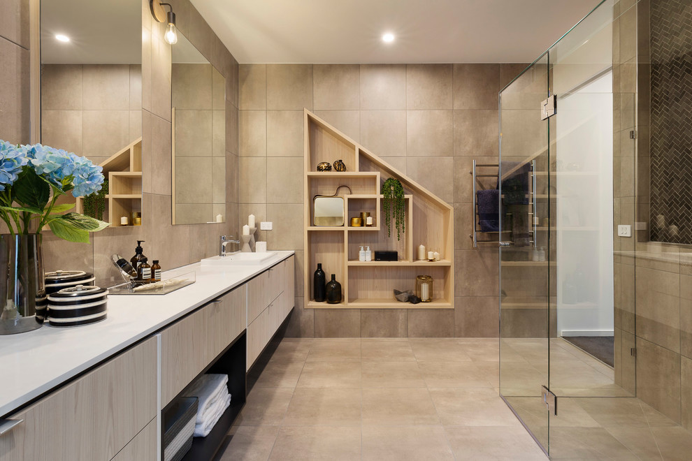 Design ideas for a large contemporary ensuite bathroom in Melbourne with flat-panel cabinets, ceramic tiles, ceramic flooring, a hinged door, white worktops, light wood cabinets, a built-in shower, beige tiles, beige walls and beige floors.