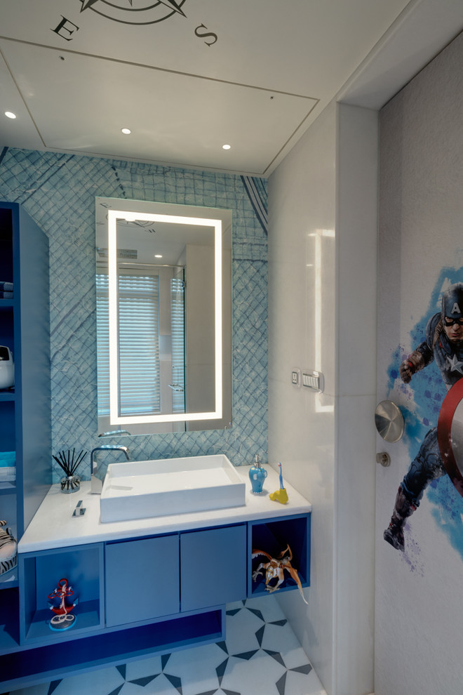 На фото: детская ванная комната среднего размера в современном стиле с синими фасадами, унитазом-моноблоком, белой плиткой, мраморной плиткой, мраморной столешницей и белой столешницей