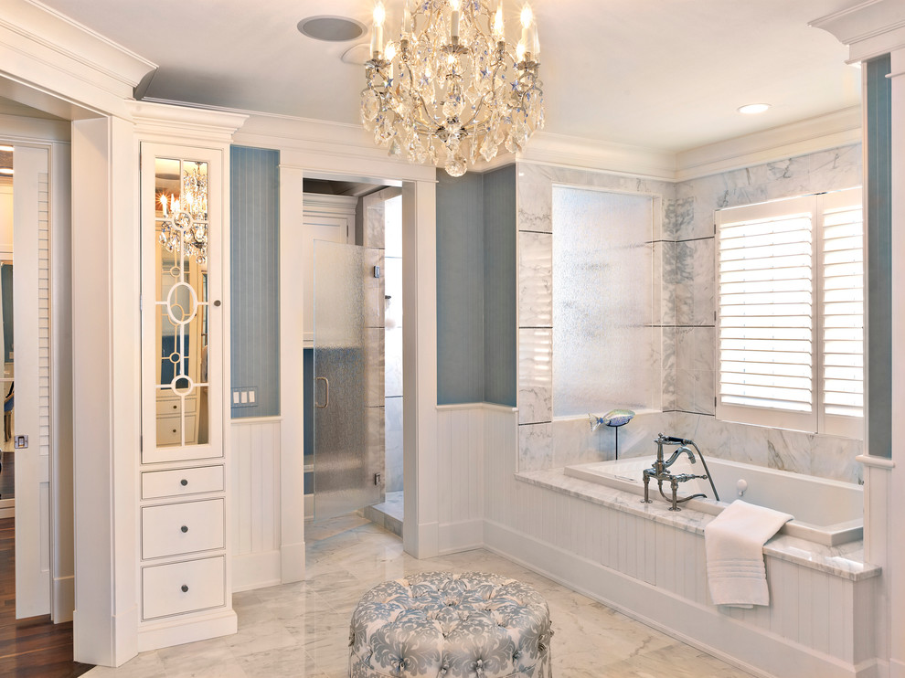 Design ideas for a large contemporary ensuite bathroom in Tampa with flat-panel cabinets, white cabinets, a built-in bath, an alcove shower, blue tiles, white tiles, blue walls, marble flooring, marble worktops, white floors and a hinged door.