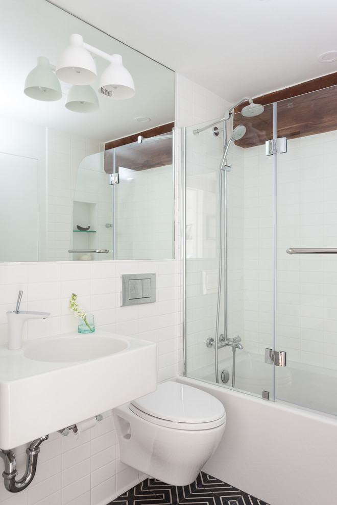 Immagine di una stanza da bagno design con lavabo sospeso e vasca/doccia