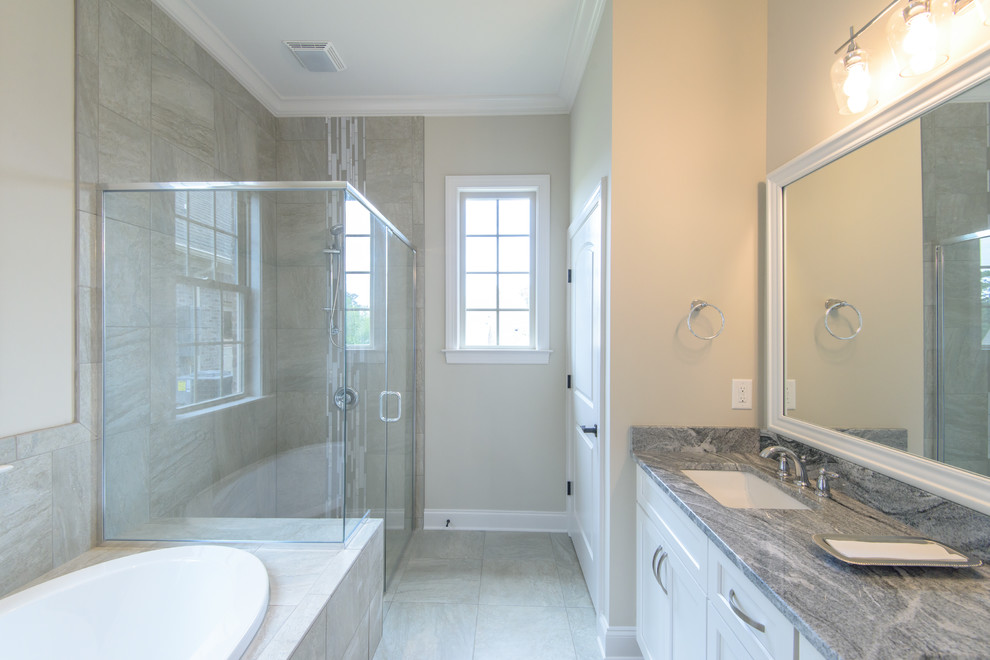 Inspiration for a mid-sized timeless master gray tile and porcelain tile porcelain tile and gray floor bathroom remodel in Other with shaker cabinets, white cabinets, a two-piece toilet, beige walls, an undermount sink, granite countertops and a hinged shower door