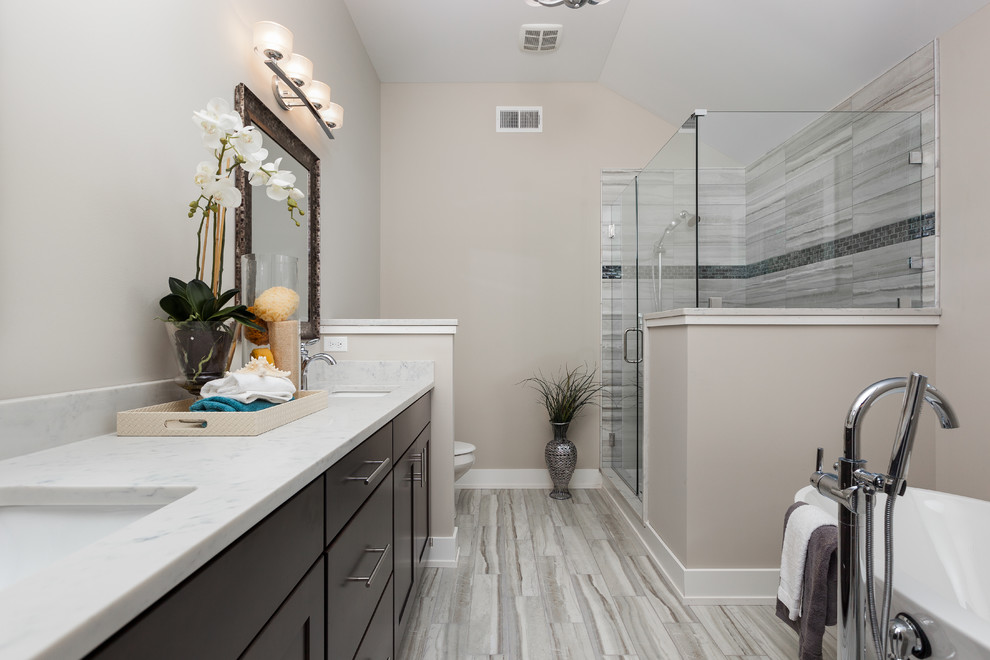 Idéer för ett mellanstort klassiskt vit en-suite badrum, med skåp i shakerstil, skåp i mörkt trä, ett fristående badkar, en hörndusch, grå kakel, porslinskakel, beige väggar, klinkergolv i porslin, ett undermonterad handfat, marmorbänkskiva, grått golv och dusch med gångjärnsdörr