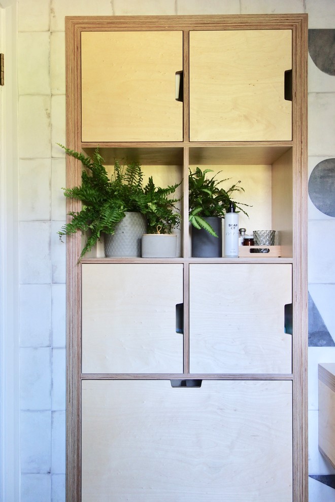 Inspiration for a scandinavian family bathroom in Other with light wood cabinets, a built-in bath, a shower/bath combination, a one-piece toilet, black and white tiles, porcelain tiles, white walls, porcelain flooring, a console sink, wooden worktops and multi-coloured floors.