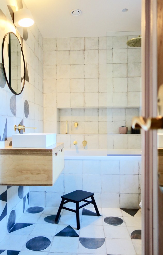 Идея дизайна: детская ванная комната в скандинавском стиле с светлыми деревянными фасадами, накладной ванной, душем над ванной, унитазом-моноблоком, черно-белой плиткой, керамогранитной плиткой, белыми стенами, полом из керамогранита, консольной раковиной, столешницей из дерева и разноцветным полом