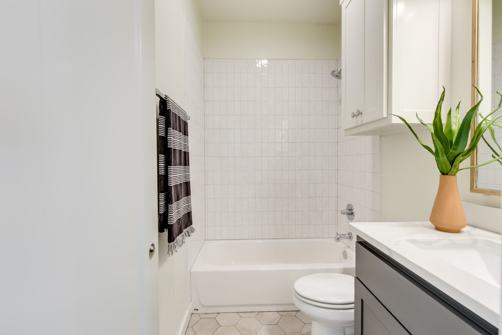 Exempel på ett mellanstort lantligt vit vitt badrum med dusch, med skåp i shakerstil, svarta skåp, ett badkar i en alkov, en dusch/badkar-kombination, en toalettstol med hel cisternkåpa, vit kakel, tunnelbanekakel, vita väggar, klinkergolv i keramik, ett undermonterad handfat, bänkskiva i kvarts, beiget golv och dusch med duschdraperi