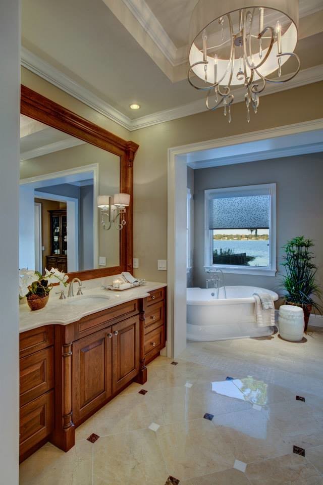 Cette image montre une très grande douche en alcôve traditionnelle en bois brun avec un lavabo intégré, un placard avec porte à panneau encastré, un plan de toilette en granite, une baignoire indépendante, WC séparés, un carrelage beige, un mur beige et un sol en marbre.