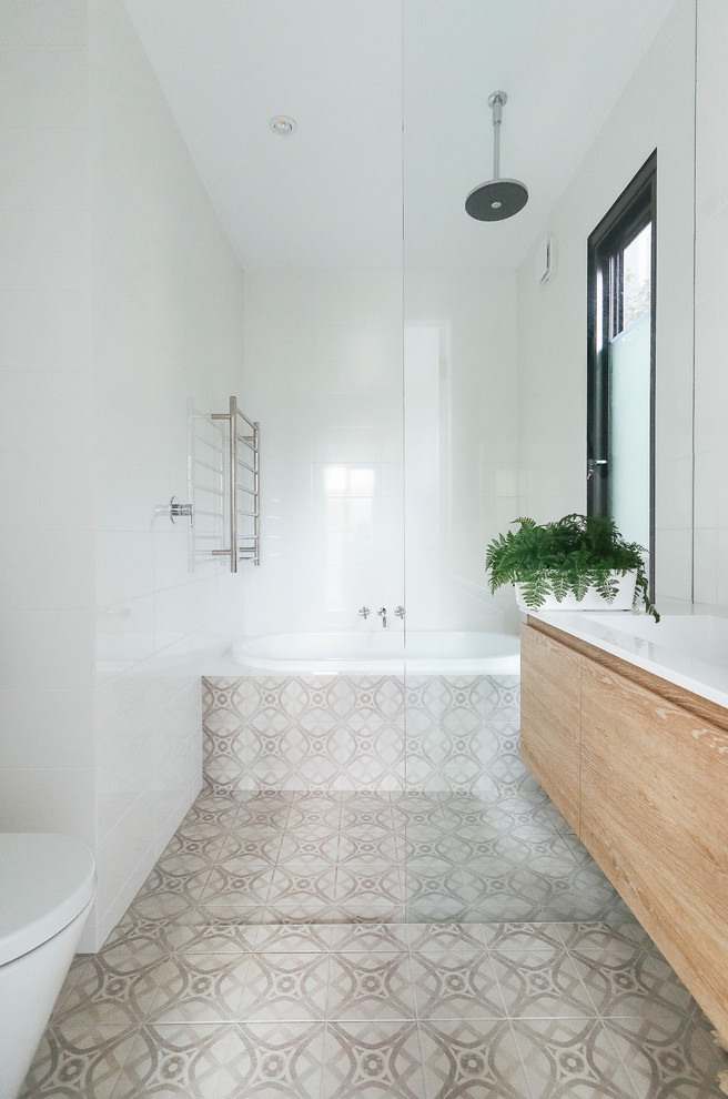 Inspiration for a small contemporary ensuite wet room bathroom in Sydney with freestanding cabinets, light wood cabinets, a wall mounted toilet, grey tiles, ceramic tiles, white walls, ceramic flooring, a wall-mounted sink, grey floors and an open shower.