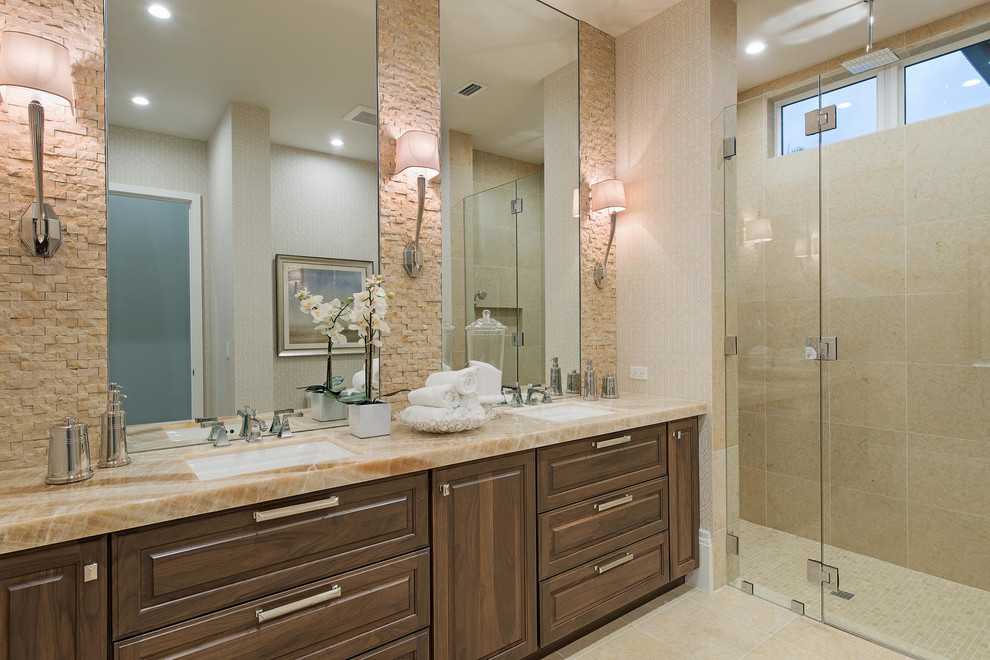 Idée de décoration pour une très grande salle de bain tradition en bois foncé avec un lavabo encastré, un plan de toilette en marbre, un carrelage beige et un mur beige.