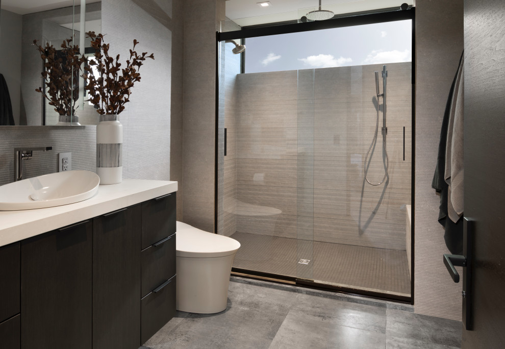 Exempel på ett mellanstort modernt vit vitt badrum med dusch, med släta luckor, skåp i mörkt trä, en toalettstol med hel cisternkåpa, porslinskakel, klinkergolv i porslin, ett fristående handfat, bänkskiva i kvarts, grått golv, dusch med skjutdörr, en dusch i en alkov, grå kakel och grå väggar