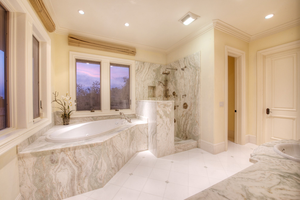 Idée de décoration pour une grande salle de bain principale méditerranéenne avec un lavabo posé, un plan de toilette en marbre, une baignoire en alcôve, une douche ouverte, un carrelage blanc, des carreaux de céramique, un mur beige et un sol en carrelage de céramique.