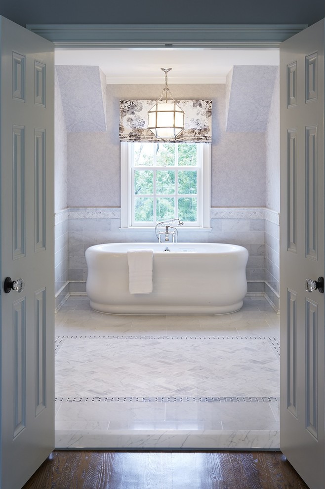 Klassisk inredning av ett mellanstort badrum, med ett fristående badkar och vit kakel