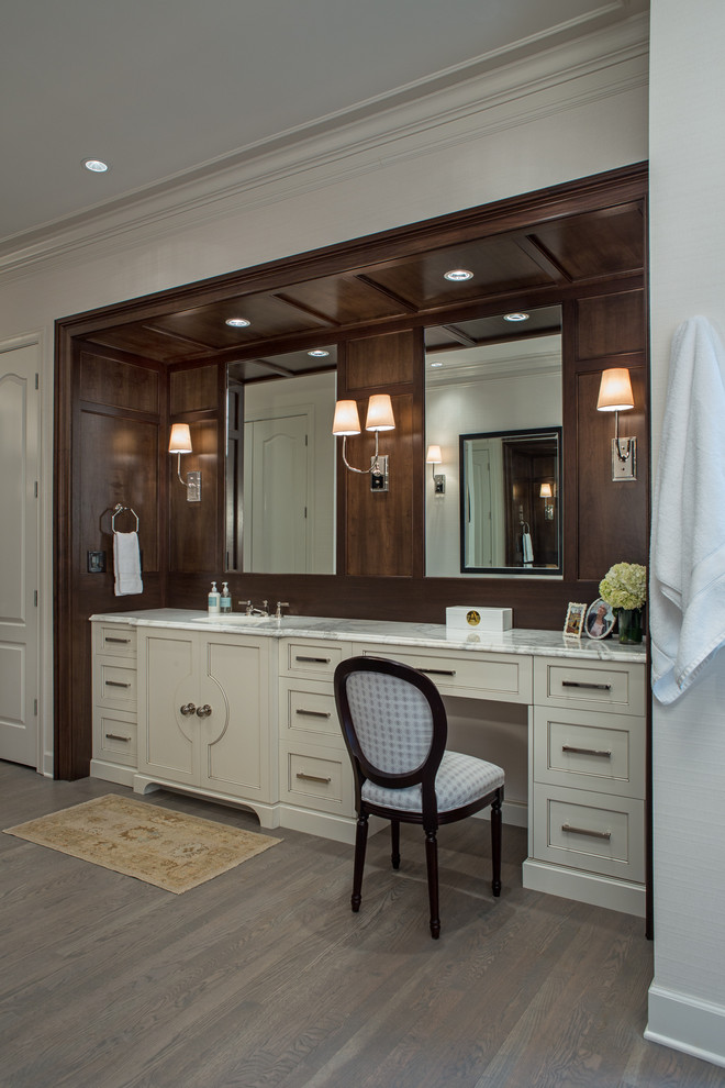 Large transitional light wood floor freestanding bathtub photo in Atlanta with an undermount sink, recessed-panel cabinets, white cabinets, marble countertops, a one-piece toilet and beige walls