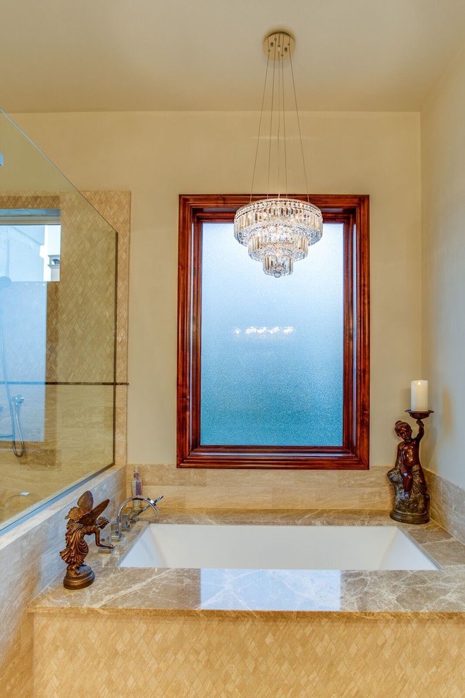 Example of a large classic master beige tile and stone tile marble floor and beige floor walk-in shower design with medium tone wood cabinets, an undermount tub, beige walls, an undermount sink, marble countertops, beaded inset cabinets, a one-piece toilet and a hinged shower door