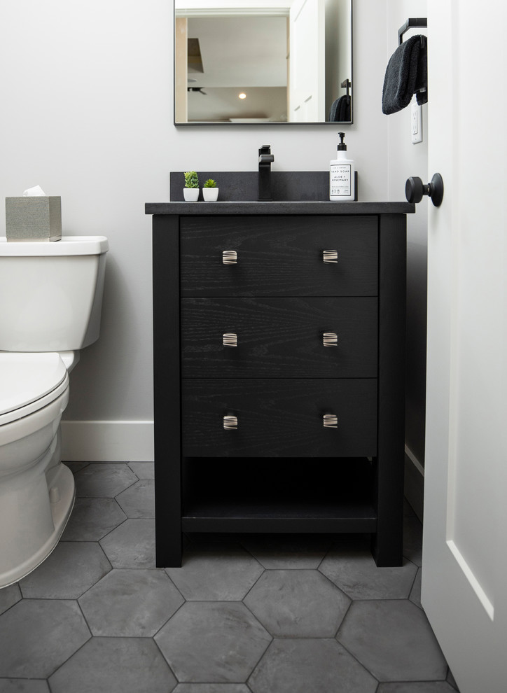 Farmhouse bathroom in Grand Rapids with freestanding cabinets, black cabinets, grey walls, a submerged sink, engineered stone worktops, grey floors and black worktops.