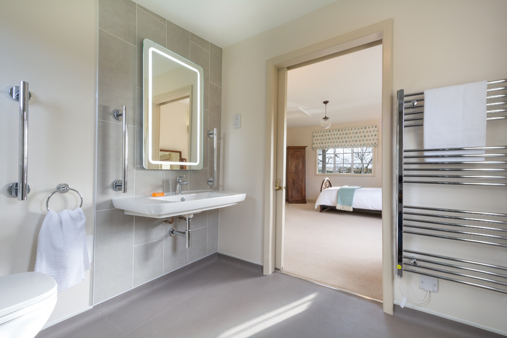 Cette image montre une salle de bain design avec un lavabo suspendu et WC séparés.