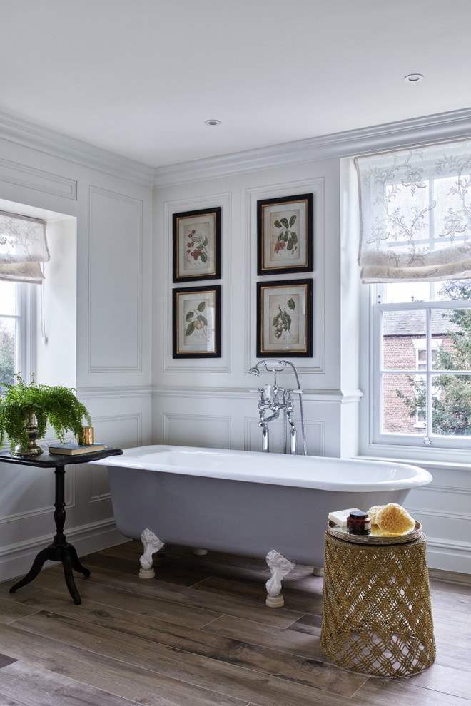 Immagine di una stanza da bagno chic con vasca con piedi a zampa di leone, pareti bianche e pavimento marrone