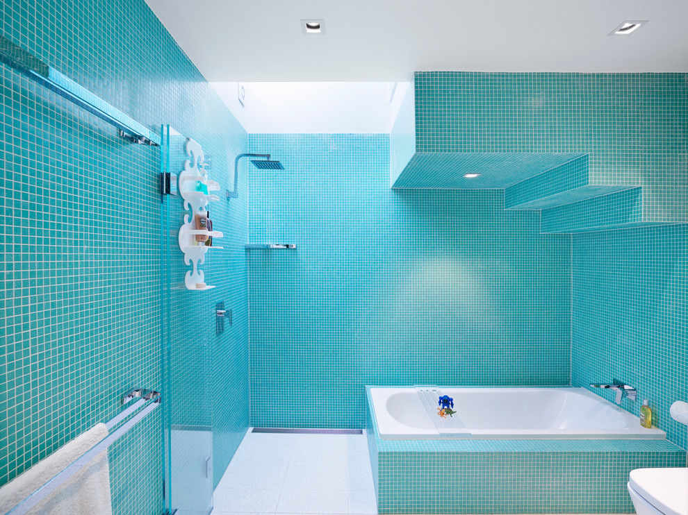 Idéer för funkis badrum för barn, med ett platsbyggt badkar, en hörndusch, blå kakel, mosaik och blå väggar