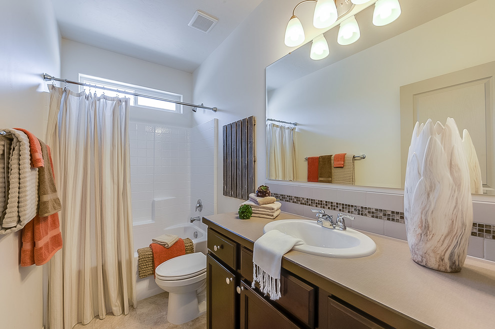 Идея дизайна: ванная комната в стиле кантри с коричневыми фасадами, душем над ванной, унитазом-моноблоком, полом из винила, столешницей из ламината и бежевой столешницей