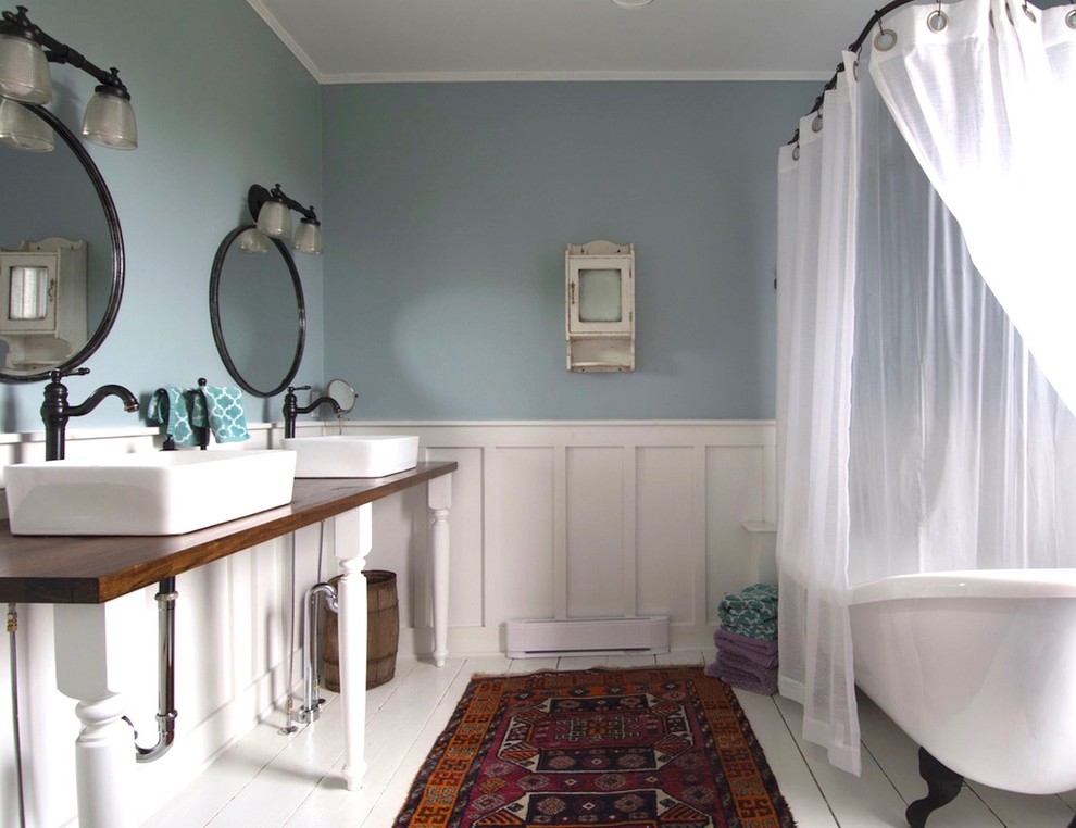 Esempio di una stanza da bagno country con vasca con piedi a zampa di leone, vasca/doccia, pareti blu, pavimento in legno verniciato, lavabo a bacinella, pavimento bianco e doccia con tenda