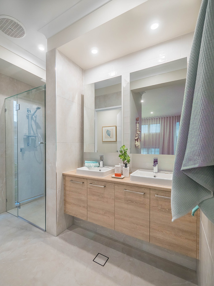 Exemple d'une salle de bain bord de mer avec un carrelage gris, des carreaux de céramique, un mur gris, un sol en carrelage de céramique, un plan de toilette en stratifié, un sol gris et une cabine de douche à porte battante.