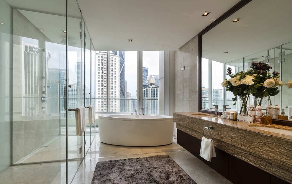 Inspiration for a contemporary ensuite bathroom in Singapore with a freestanding bath, a built-in shower, grey tiles, white walls, a submerged sink, grey floors, a hinged door and brown worktops.