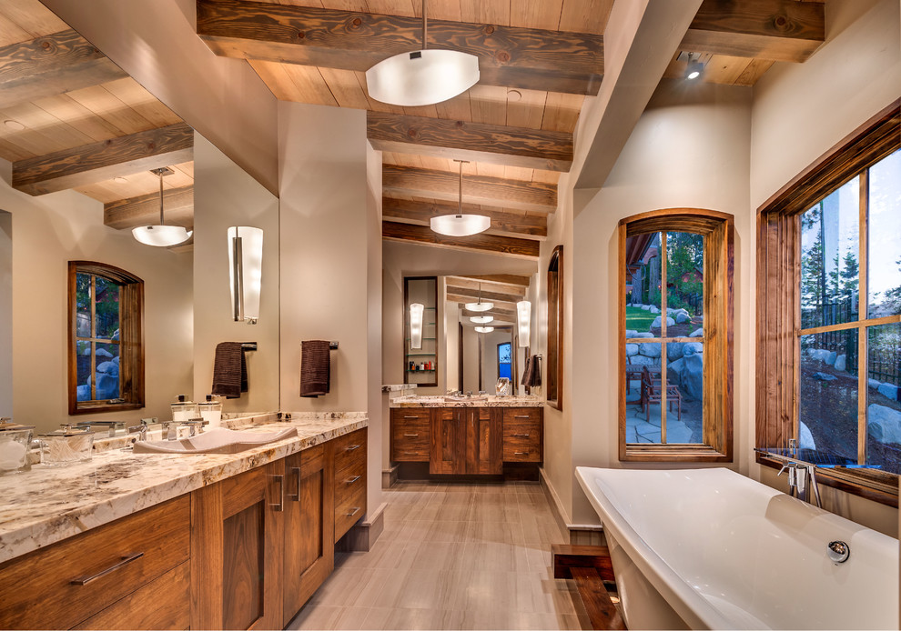 Rustic bathroom in Sacramento with shaker cabinets, medium wood cabinets, a freestanding bath, limestone flooring, a vessel sink and marble worktops.
