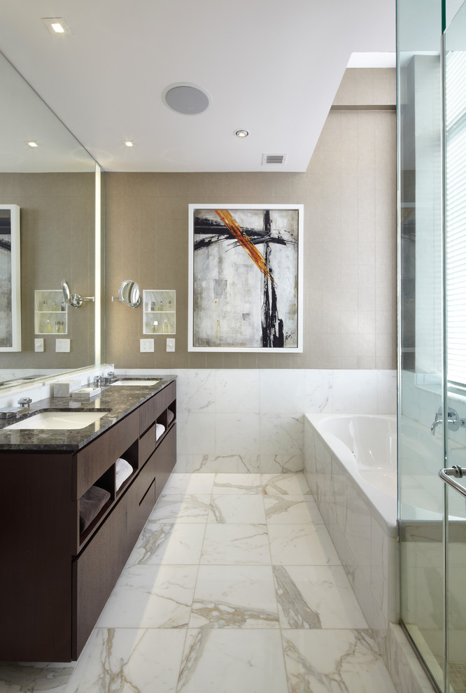 Inspiration for a mid-sized contemporary master white tile and porcelain tile marble floor and white floor bathroom remodel in New York with an undermount sink, flat-panel cabinets, dark wood cabinets, beige walls, granite countertops and a hinged shower door