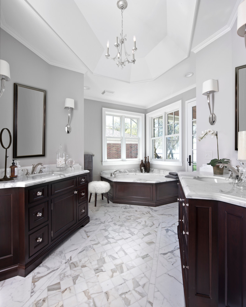 Immagine di una stanza da bagno padronale chic con ante a filo, ante nere, vasca sottopiano, doccia a filo pavimento, piastrelle bianche, piastrelle in pietra e top in marmo