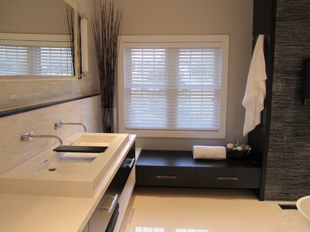 Свежая идея для дизайна: ванная комната в стиле модернизм с настольной раковиной, плоскими фасадами, черными фасадами, отдельно стоящей ванной и серой плиткой - отличное фото интерьера