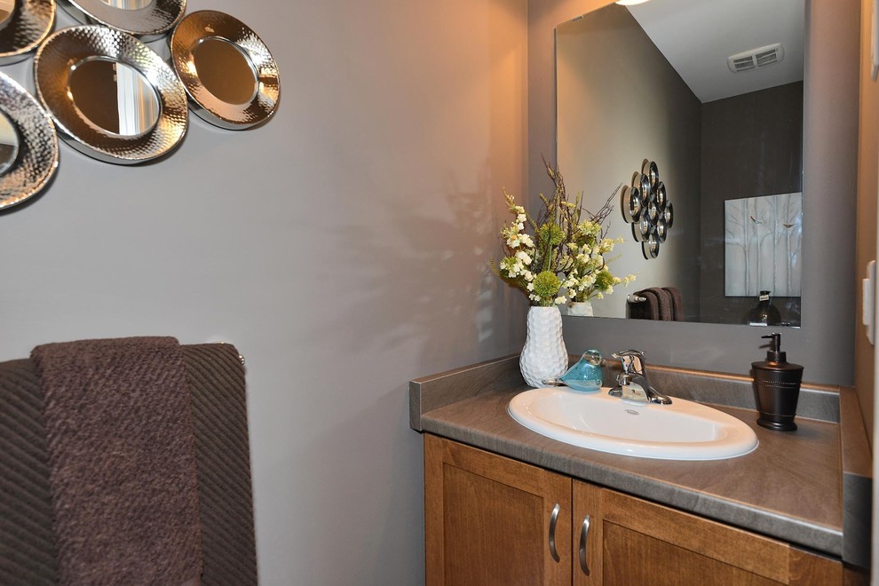 Ejemplo de cuarto de baño tradicional con armarios estilo shaker, puertas de armario de madera oscura, paredes grises, lavabo encastrado, encimera de granito y encimeras grises