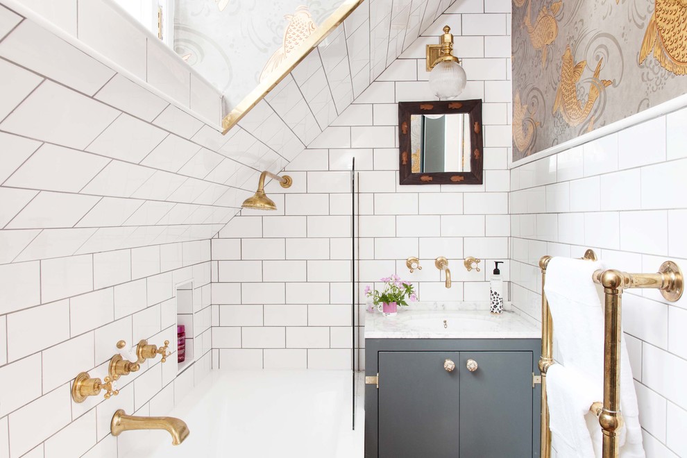 Medium sized eclectic bathroom with flat-panel cabinets, grey cabinets, a built-in bath, white tiles, metro tiles, a submerged sink and marble worktops.