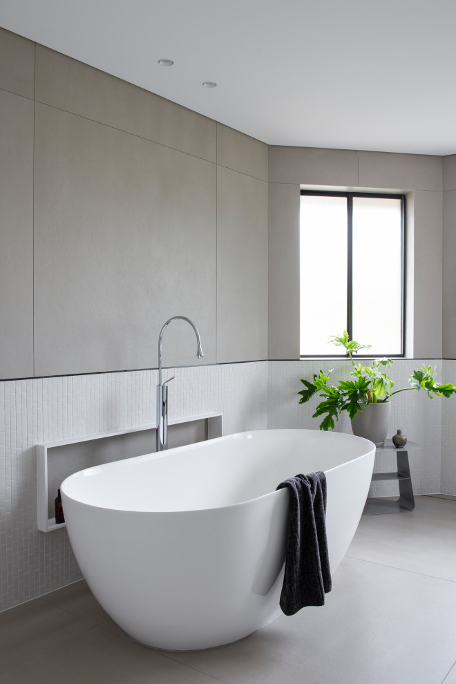 This is an example of a large contemporary bathroom in Sydney with a freestanding bath, multi-coloured tiles, mosaic tiles, porcelain flooring and grey floors.