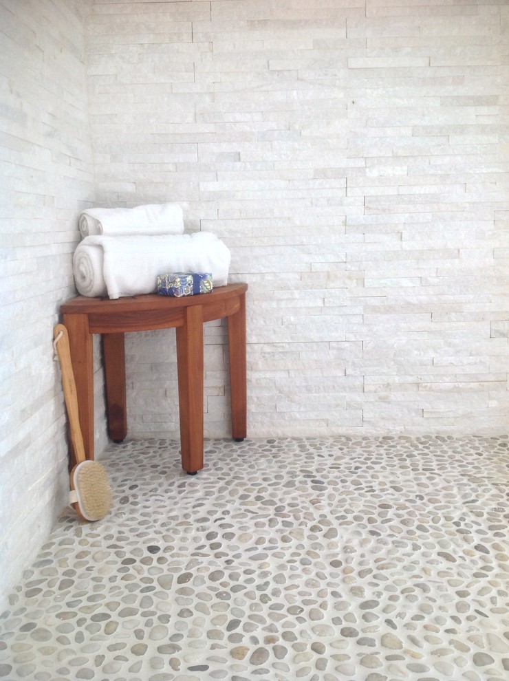 На фото: главная ванная комната в стиле модернизм с открытым душем, каменной плиткой и полом из галечной плитки с