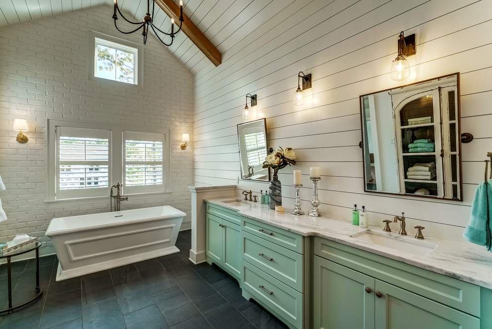 Photo of an expansive rural ensuite bathroom in Richmond with shaker cabinets, turquoise cabinets, a freestanding bath, an alcove shower, a one-piece toilet, white walls, ceramic flooring, a submerged sink, granite worktops, grey floors and a hinged door.