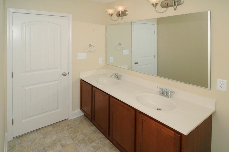 Example of a trendy alcove shower design in Raleigh with an integrated sink and a two-piece toilet