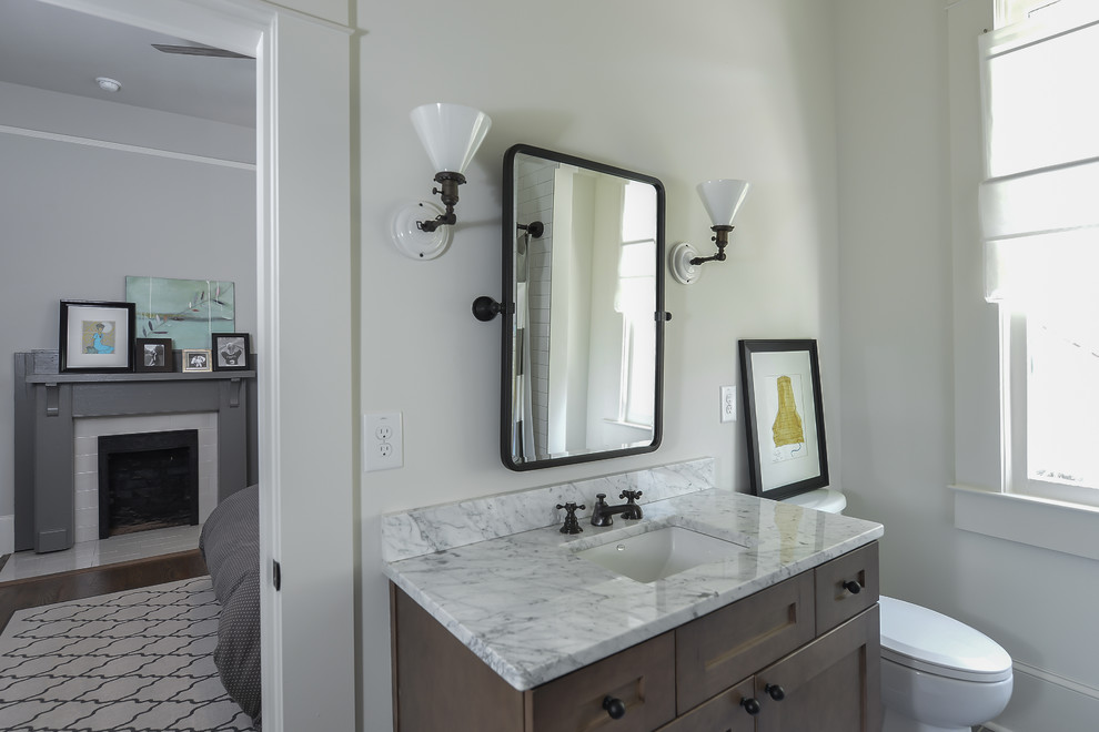 This is an example of a traditional bathroom in Atlanta with shaker cabinets, brown cabinets, black tiles, ceramic tiles, white walls, a submerged sink and marble worktops.