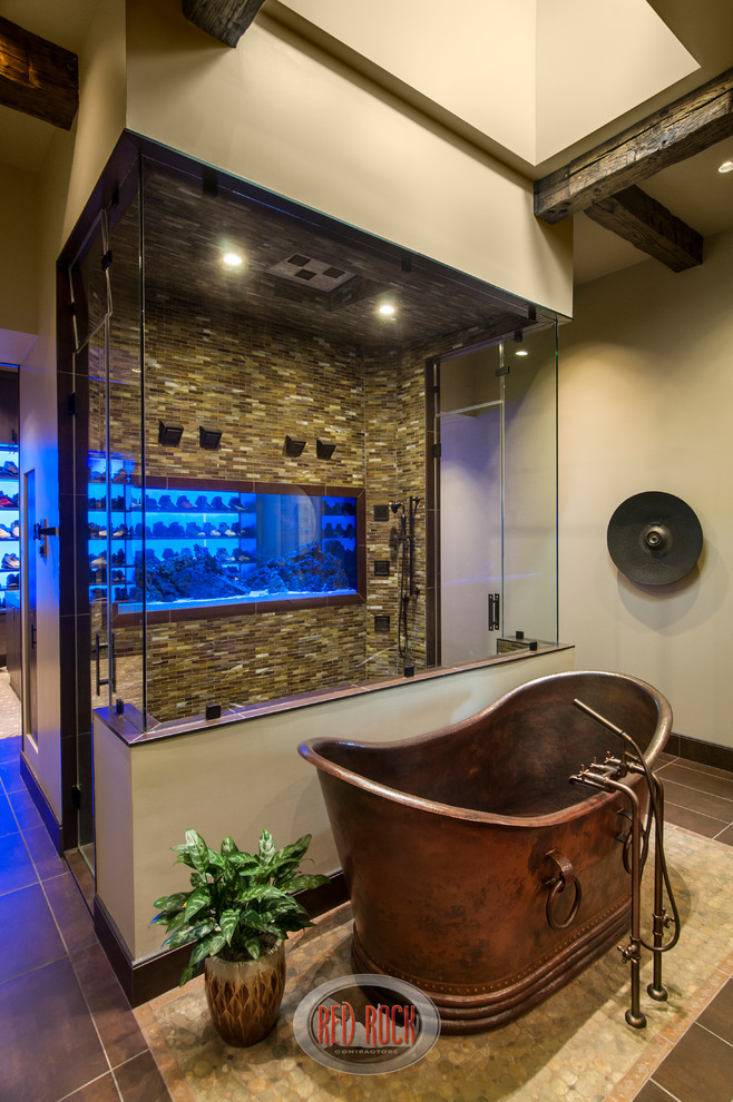 Пример оригинального дизайна: огромная главная ванная комната в стиле рустика с монолитной раковиной, отдельно стоящей ванной, двойным душем, унитазом-моноблоком, коричневой плиткой, стеклянной плиткой, бежевыми стенами и полом из керамической плитки