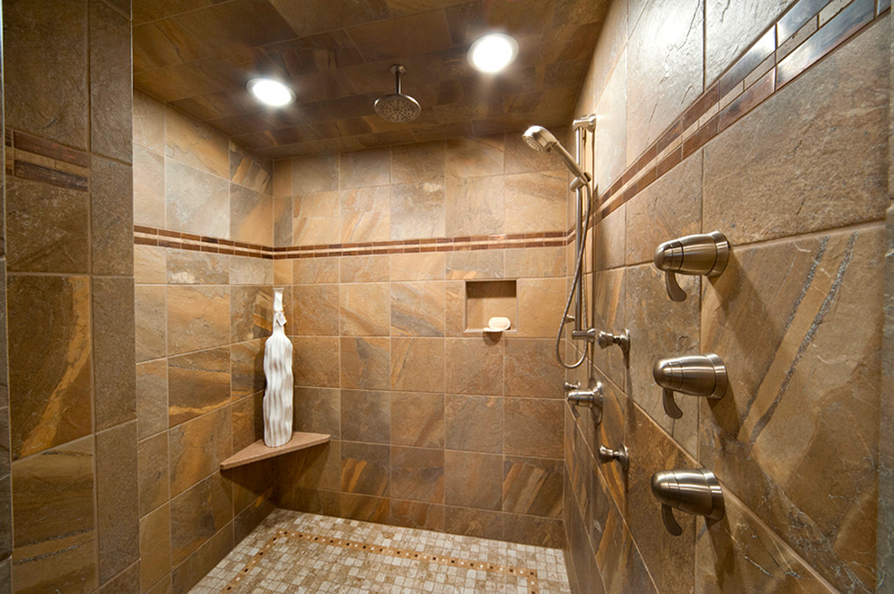 Photo of a small country ensuite bathroom in Other with a vessel sink, shaker cabinets, medium wood cabinets, granite worktops, a built-in bath, a walk-in shower, a one-piece toilet, beige tiles, stone tiles, grey walls and travertine flooring.