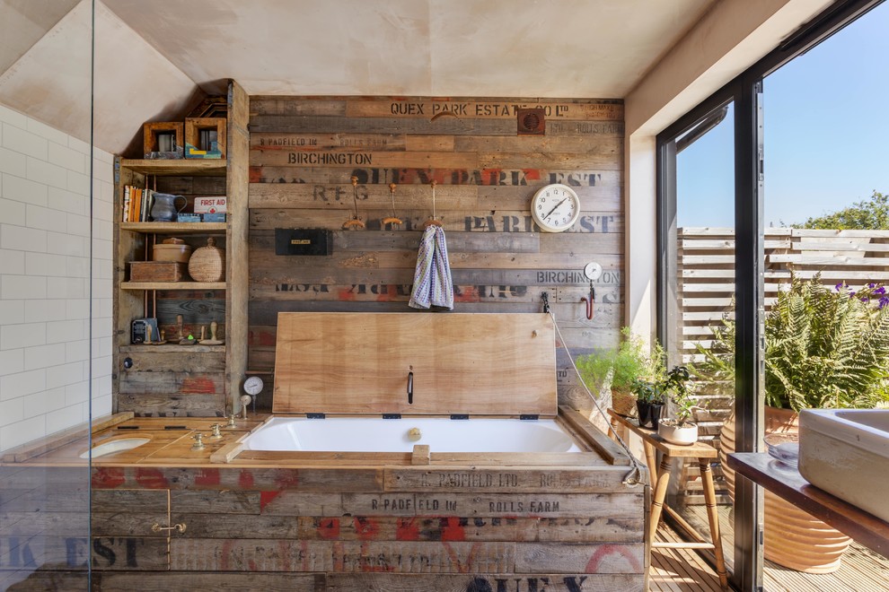 Bild på ett maritimt badrum, med ett undermonterat badkar, vit kakel, vita väggar, mellanmörkt trägolv och brunt golv