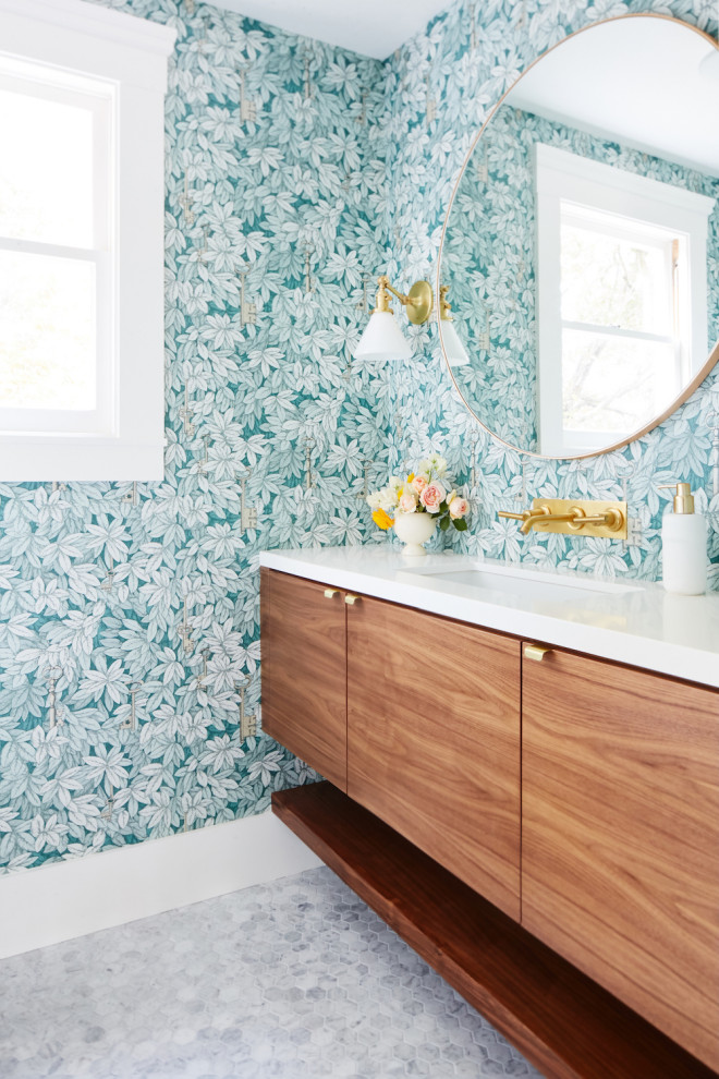 Immagine di una stanza da bagno classica con ante lisce, ante in legno scuro, pareti blu, pavimento con piastrelle a mosaico, lavabo sottopiano, pavimento grigio, top bianco, un lavabo, mobile bagno sospeso e carta da parati